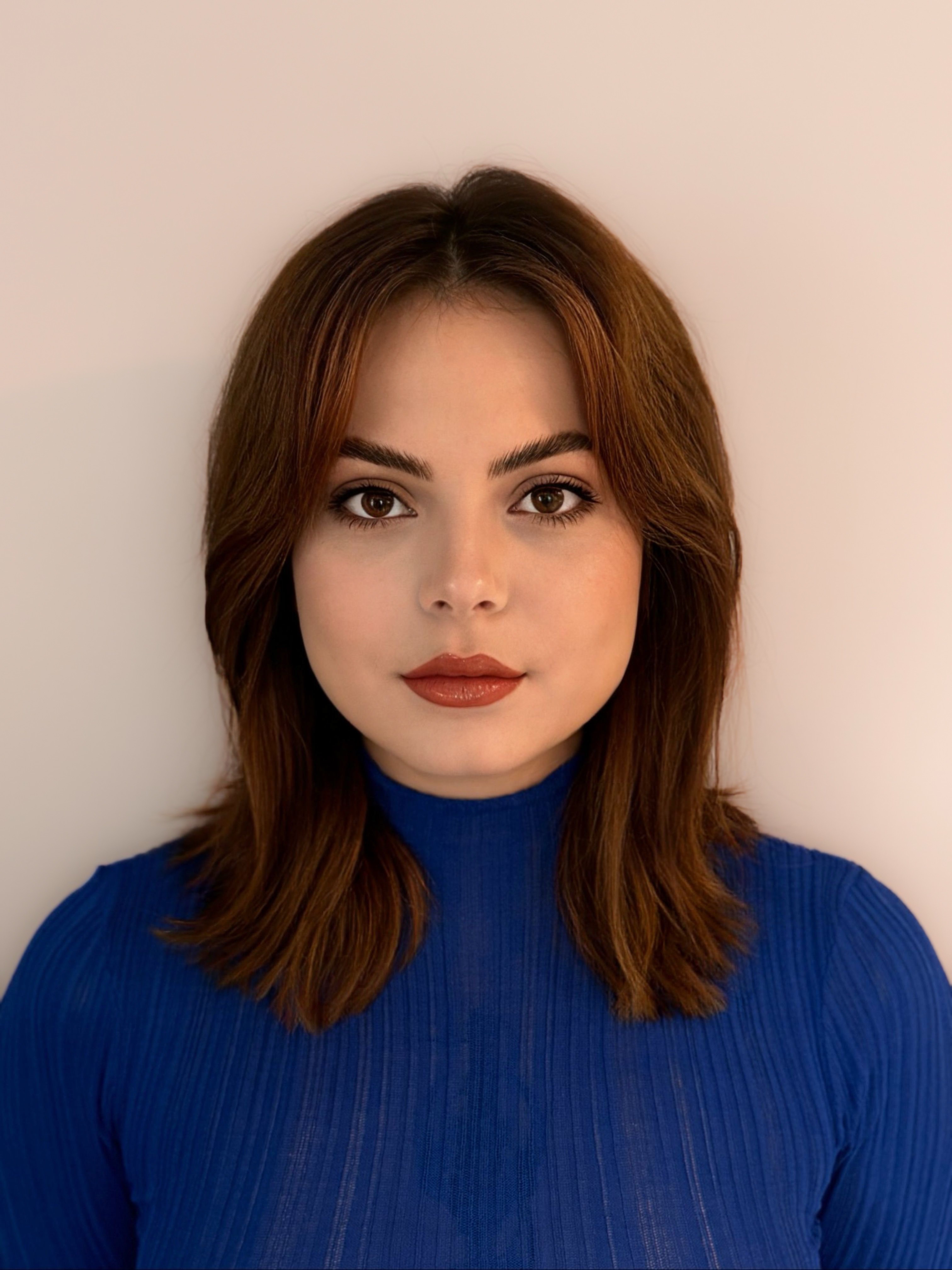 Portrait photo of Yuliia Alieksieieva, 3D artist, with a neutral background and blue top.